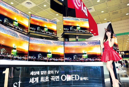 지난해 5월 서울 삼성동 코엑스에서 열린 ‘월드 IT쇼 2013’에서 모델들이 LG전자(왼쪽)와 삼성전자의 곡면 OLED TV를 소개하고 있다. 한경DB