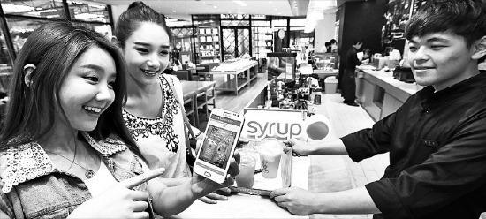 판교 아브뉴프랑 카페에서 소비자가 비콘 기술이 적용된 ‘시럽’ 앱의 음료쿠폰을 사용하고 있다. /SK플래닛 제공 