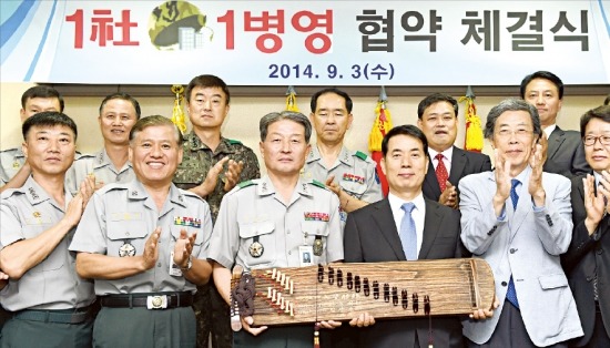 임성호 육군종합행정학교장(앞줄 왼쪽 세 번째)과 이두식 이텍산업 회장(네 번째)이 3일 이텍산업 임원과 종행교 간부들이 박수를 치는 가운데 ‘1사 1병영 결연’이란 축하 문구가 새겨진 가야금을 들고 상호교류를 다짐하고 있다. 영동(충북)=강은구 기자 egkang@hankyung.com