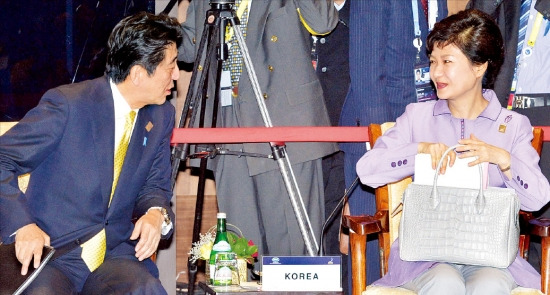 아베 신조(安倍晋三) 일본 총리(왼쪽)가 지난해 10월 인도네시아 발리에서 열린 아시아·태평양경제협력체(APEC) 남태평양 도서국 정상들과의 대화에서 박근혜 대통령에게 말을 건네고 있다. 연합뉴스