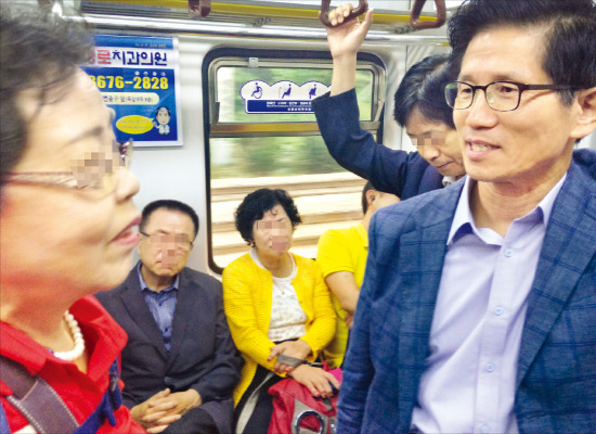 김문수 새누리당 보수혁신특별위원장(오른쪽)이 19일 지하철 1호선 출근길에서 한 시민과 얘기하고 있다. 은정진 기자