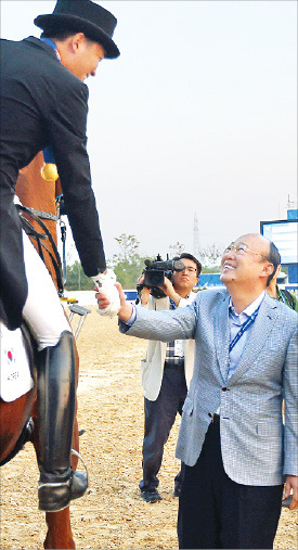 김승연 한화그룹 회장(오른쪽)이 마장마술 단체전 금메달을 차지한 막내아들(3남) 김동선 선수를 축하해주고 있다. 연합뉴스