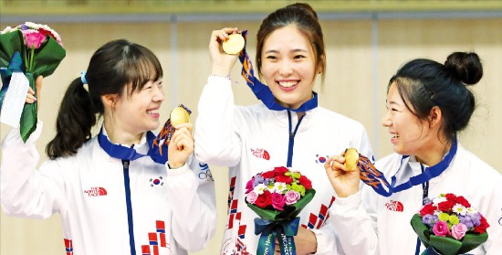 인천 옥련국제사격장에서 24일 열린 사격 여자 50m 소총 단체전에서 금메달을 획득한 여자사격팀 나윤경(왼쪽부터), 정미라, 음빛나가 시상대에서 환하게 웃고 있다. 연합뉴스