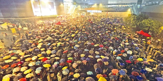 < 도심 뒤덮은 우산 > 홍콩 행정장관 선거의 완전 자유직선제를 요구하는 시위대들이 30일 밤 폭우가 내리는 가운데 홍콩 정부청사 앞 광장에서 우산을 펼쳐든 채 시위를 벌이고 있다. 홍콩AP연합뉴스