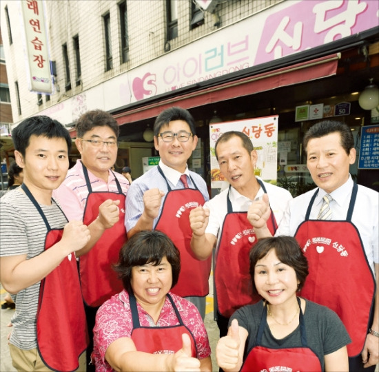 서울 신당동 떡볶이골목에 있는 아이러브신당동은 7명의 상인이 만든 주식회사다. 앞줄 왼쪽부터 시계 반대 방향으로 서기순, 최미옥, 오진섭, 조성배, 박찬영, 이윤근 씨 등 주주들이 파이팅을 외치고 있다. 또 다른 주주 김봉희 씨는 새벽 근무로 자리를 비워 직원(윗줄 맨 왼쪽)이 대신 사진을 찍었다. 신경훈 기자 nicerpeter@hankyung.com