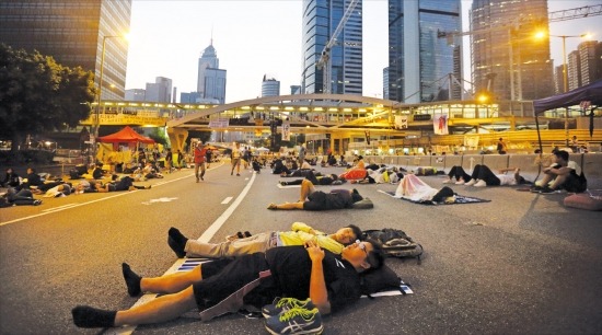 < 지친 학생들 > 홍콩의 시위 참가자들이 6일 오전 정부청사 부근 도로에서 잠을 자고 있다. 시위대는 이날 정부청사 봉쇄를 풀고 정부 측과 대화에 나서기로 했다. 홍콩블룸버그연합뉴스