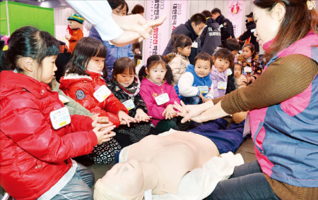 지난해 열린 ‘2013 대한민국 사회안전박람회’에 참석한 유치원생들이 심폐소생술을 배우고 있다. 한경DB