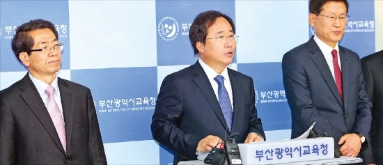 < 부산교육감 “중학교 무상급식 1년 유예” > 김석준 부산교육감(가운데)이 7일 부산교육청에서 기자회견을 열고 중학교 무상급식 시행을 1년간 유예하겠다고 밝혔다. 김 교육감은 예산을 편성하지 못한 누리과정 어린이집 보육료 585억원에 대한 정부의 지원을 촉구했다. 연합뉴스