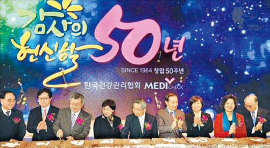 최근 서울 여의도 63빌딩에서 열린 한국건강관리협회 창립 50주년 기념식에서 관계자들이 떡을 자르고 있다.  한국건강관리협회 제공 