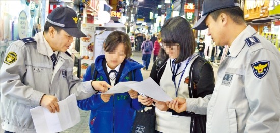 서울 은평경찰서 학교전담경찰관(SPO)들이 지난 18일 밤 은평구 갈현동 로데오거리에서 청소년을 대상으로 ‘유해업소 출입금지’를 설명하는 안내물을 나눠주고 있다. 은평경찰서 제공