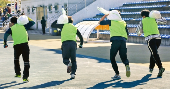 지난달 14일 강원 강릉시 강남축구공원에서 열린 2014년도 강릉시 환경미화원 공개채용 체력검사에서 지원자들이 모래주머니를 메고 100m 달리기를 하고 있다. 연합뉴스