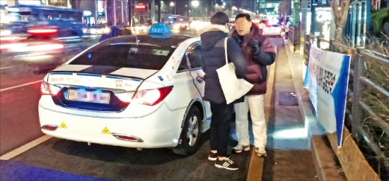 강남경찰서 소속 경찰관들이 13일 새벽 강남역 인근에서 과다요금을 요구한 택시를 현장에서 단속하고 있다. 홍선표 기자