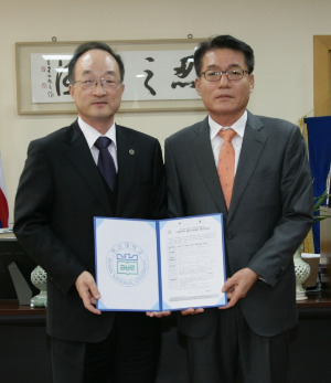 황상문 부산대 교수(오른쪽)가 김기섭 총장에게 발전기금을 전달한 뒤 기념촬영하고 있다. / 부산대 제공