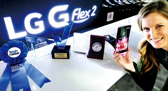 < LG G플렉스2 ‘10관왕’ > 세계 최대 가전전시회 ‘CES 2015’가 9일 폐막했다. LG전자가 이번 행사에서 공개한 커브드 스마트폰 ‘G플렉스2’는 리뷰드닷컴 등 해외 매체로부터 10개의 상을 받았다. LG전자 모델이 수상 트로피를 배경으로 G플렉스2를 소개하고 있다. 연합뉴스