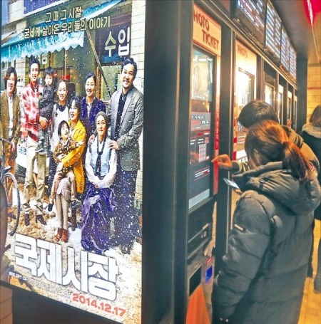 서울 여의도의 한 극장을 찾은 관객이 영화 ‘국제시장’을 보기 위해 티켓을 사고 있다.