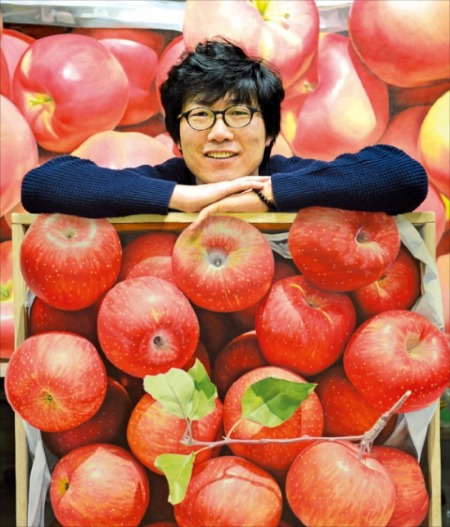 극사실주의 화가 윤병락 씨가 경기도 일산 작업실에서 자신의 작품 ‘가을향기’ 시리즈를 내보이며 웃고 있다.