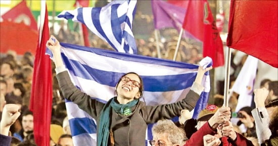 긴축정책에 반대하는 그리스 시민들이 그리스 국기를 들고 아테네 시내에서 시위를 벌이고 있다. 한경DB 