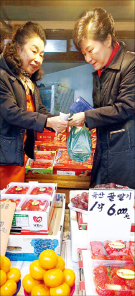 박근혜 대통령이 10일 서울 중곡제일시장을 방문, 한 가게에 들러 과일을 사고 있다. 연합뉴스