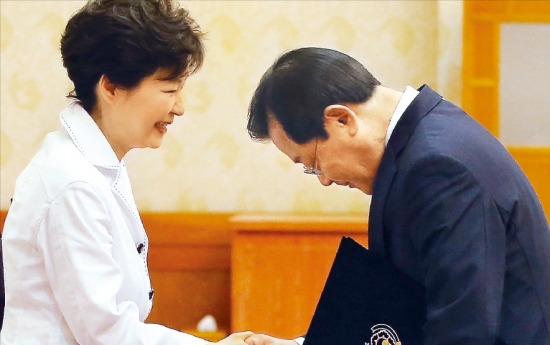 이병기 신임 대통령 비서실장이 지난해 7월 박근혜 대통령으로부터 국정원장 임명장을 받은 뒤 악수하고 있다. 연합뉴스