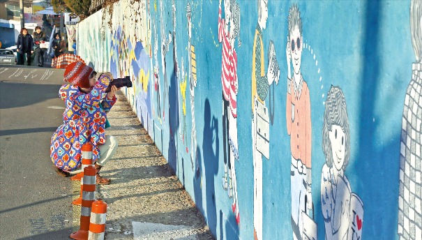 경남 통영 동피랑 벽화마을에서 벽화사진을 찍는 어린아이. 