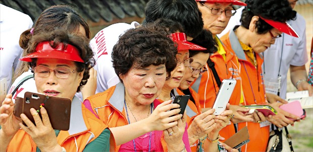 서울 경복궁에서 열린 ‘SK텔레콤 이음페스티벌’ 행사에서 참가 노인들이 스마트폰 활용 교육을 받고 있다. 연합뉴스