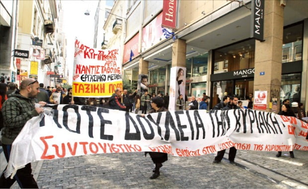 그리스 상점 종업원들이 쇼핑객으로 북적이는 아테네 에르무 거리에서 ‘일요일에는 절대 일하지 않는다’는 플래카드를 들고 시위하고 있다.  