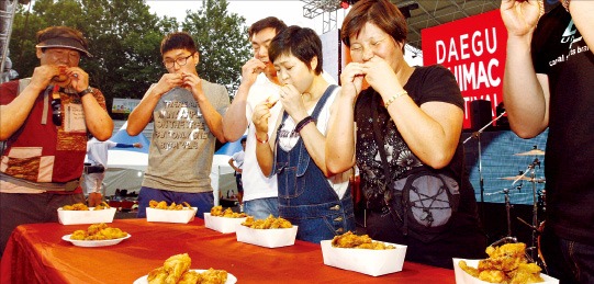 지난해 7월 대구 두류공원에서 열린 ‘2014 대구치맥페스티벌’에 참가한 시민들이 치킨 빨리먹기 시합을 하고 있다. 대구시 제공