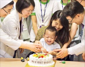 네 살배기 뇌사자의 소화장기 6개를 한꺼번에 이식받고 새 생명을 얻은 신모군(2)이 지난 1일 퇴원에 앞서 의료진의 축하를 받고 있다. 서울성모병원 제공