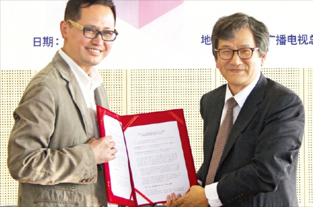 이봉구 한국경제신문 상무(오른쪽)와 쉬청융 장쑤방송그룹 유만카퉁채널 사장이 21일 중국 난징에서 ‘한·중 스토리 공동개발 프로젝트’ 업무협약을 맺은 뒤 협약서를 들어 보이고 있다.