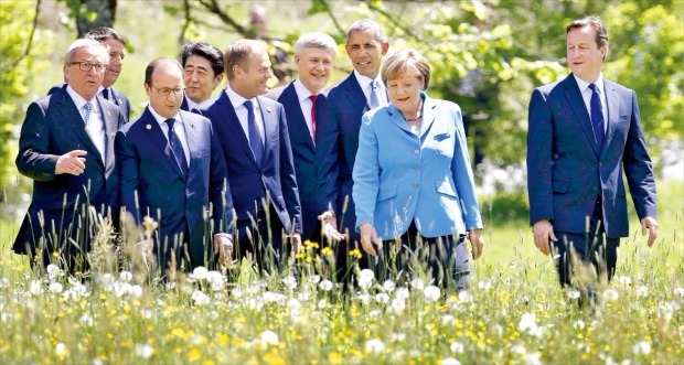 < 꽃밭 걷는 G7 정상 > 주요 7개국(G7) 정상회의를 위해 7일(현지시간) 독일 남부 바이에른주 크륀에 모인 각국 정상들이 회담장인 엘마우호텔로 들어가기 위해 꽃밭을 걸어가고 있다. 왼쪽부터 장클로드 융커 유럽연합(EU) 집행위원장, 마테오 렌치 이탈리아 총리, 프랑수아 올랑드 프랑스 대통령, 아베 신조 일본 총리, 도날트 투스크 EU 정상회의 상임의장, 스티븐 하퍼 캐나다 총리, 버락 오바마 미국 대통령, 앙겔라 메르켈 독일 총리, 데이비드 캐머런 영국 총리. 크륀EPA연합뉴스 