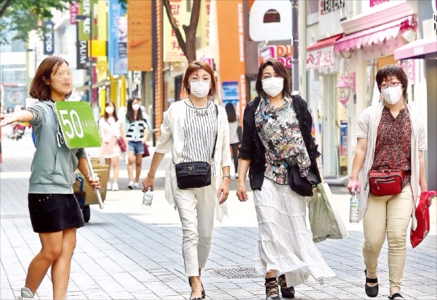 < 한산한 명동거리 > 중동호흡기증후군(MERS·메르스)이 확산되면서 관광객들이 9일 서울 명동거리에서 마스크를 쓴 채 쇼핑하고 있다. 허문찬 기자 sweat@hankyung.com