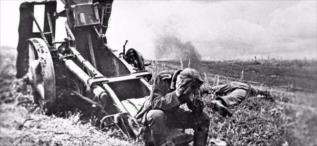 1943년 7월 독일군과 소련군의 탱크전이 벌어진 쿠르스크 전장에서 한 독일군 포병이 머리를 감싸쥔 채 앉아 있다. 이 전쟁의 패배로 소련을 점령하겠다는 히틀러의 야망이 무너졌다. 지식의날개 제공