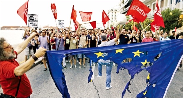< “긴축 반대” > 그리스 테살로니키 시민들이 28일(현지시간) 불에 탄 유럽연합(EU) 깃발을 들고 채권단이 요구하는 추가 긴축안에 반대하는 시위를 하고 있다. 테살로니키블룸버그연합뉴스