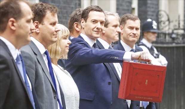 조지 오즈번 영국 재무장관 이 8일(현지시간) 런던 총리관저 앞에서 2015년 예산안이 담긴 가방을 흔들어 보이고 있다. 영국에서는 예산안 발표 당일 서류를 잘 챙겼다는 의미로 빨간 서류가방을 흔드는 전통이 150년 가까이 이어지고 있다. 런던블룸버그연합뉴스