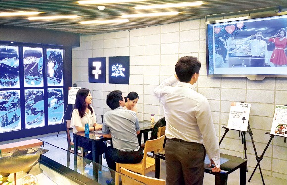 서울 명동의 세븐일레븐 중국대사관점에서 소비자가  증강현실기술을 이용해 걸그룹 걸스데이의 멤버 혜리와 사진을 찍고 있다. 세븐일레븐 제공