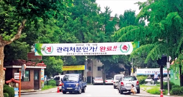 경기 과천시 별양동 주공7-2 단지 입구에 재건축 인허가 마지막 단계인 관리처분인가를 받은 것을 축하하는 현수막이 붙어 있다. 지난달 이주에 들어간 이 단지는 오는 10월까지 조합원 이주를 끝낼 예정이다. 윤아영 기자