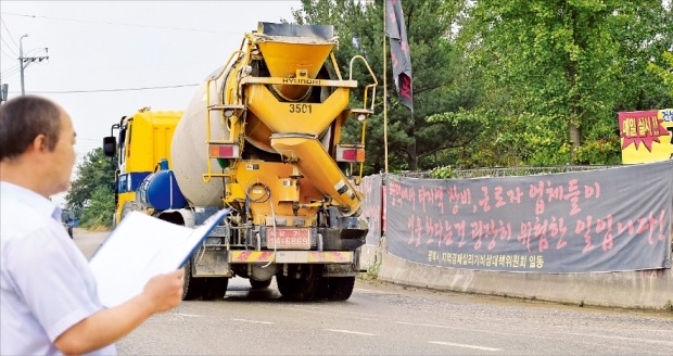 삼성전자 평택 반도체공장이 건설 중인 경기 평택시 고덕면 지제교차로에 24일 ‘평택에서 타 지역 장비, 근로자 업체들이 일을 하는 건 굉장히 위험한 일입니다’는 내용의 현수막이 걸려 있다. 평택=신경훈 기자 nicerpeter@hankyung.com