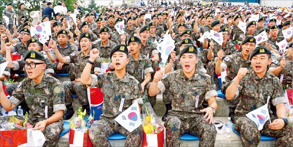 경기 포천 승진과학화훈련장에서 28일 열린 ‘2015 통합화력 격멸훈련’ 관객석에서 남북 군사 대치 때 전역을 연기한 장병들이 태극기를 흔들며 함성을 지르고 있다. 강은구 기자 egkang@hankyung.com