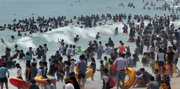  (부산=연합뉴스) 조정호 기자 = 부산에 폭염주의보가 14일째    계속되는 가운데 9일 해운대해수욕장에서 피서객들이 물놀이를 즐기고 있다. 해운대에는 이날 60만명의 피서객이 몰렸다.