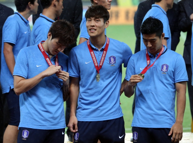 9일 중국 후베이성 우한 스포츠센터에서 열린 동아시안컵 축구대회에서 우승한 한국 선수들이 시상식에서 받은 메달을 살펴보고 있다.  