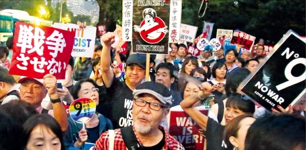 < “전쟁 반대·아베 사퇴” > 일본의 집단적 자위권 행사를 용인하는 안보 관련 법안에 반대하는 시위대가 18일 오후 도쿄 국회의사당 앞에서 ‘전쟁 반대’ ‘아베 사퇴’ 등이 적힌 푯말을 들고 시위를 벌이고 있다. 도쿄AP연합뉴스