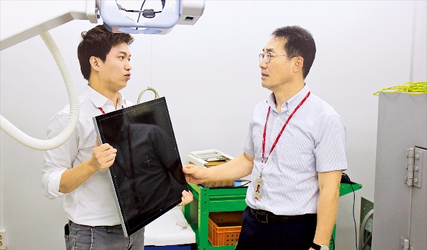 현정훈 레이언스 사장(오른쪽)이 본사 연구소에서 직원과 디지털 엑스레이 핵심부품인 디텍터 개발방향에 대해 얘기하고 있다. 김낙훈 기자 