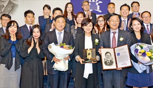 창업경영인 부문 다산경영상을 받은 서경배 아모레퍼시픽그룹 회장(앞줄 오른쪽 두 번째)과 부인 신윤경 씨(세 번째)가 임직원들에게 축하를 받으며 활짝 웃고 있다. 김병언 기자 misaeon@hankyung.com