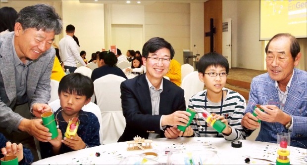 한국공학한림원이 지난 17일 서울대 글로벌공학교육센터에서 연 ‘공학한마당’ 행사에서 이학성 LS산전 부사장(왼쪽 첫 번째), 박성욱 SK하이닉스 사장(세 번째), 윤종용 국가지식재산위원장(다섯 번째)이 학생들과 함께 과학키트를 만들며 환하게 웃고 있다. 한국공학한림원 제공