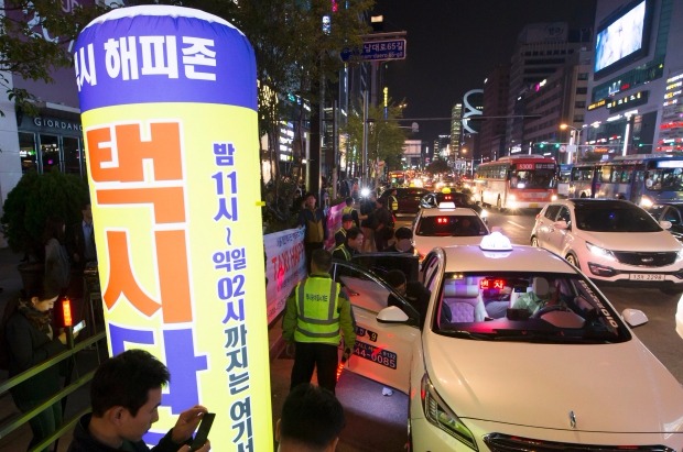 <  '불금' 강남역에선 '해피존'에서 택시 타세요 >  23일 오후 서울 강남역 부근에 설치된 택시 해피존에서 시민들이 택시를 타고 있다. 연합뉴스