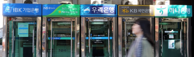 (서울=연합뉴스) 최재구 기자 = 주거래 은행 계좌를 손쉽게 옮길 수 있는 계좌이동제 시행을 하루 앞둔 29일 서울시내에 설치된 은행별 ATM기 앞을 시민들이 지나고 있다.