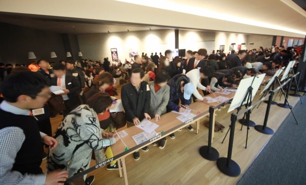 ‘e편한세상 용인 한숲시티’ 선착순 분양 첫날 인 19일. 견본주택 내부는 계약을 하기 위해 찾은 당첨자들로 하루 종일 붐볐다. 방문객들이 신착순 분양을 위해 신청서류를 작성하고 있다.