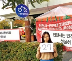 인천대 학생이 2일 시위천막 앞에서 시위 27일째를 알리는 숫자판을 들고 있다. 김인완  기자