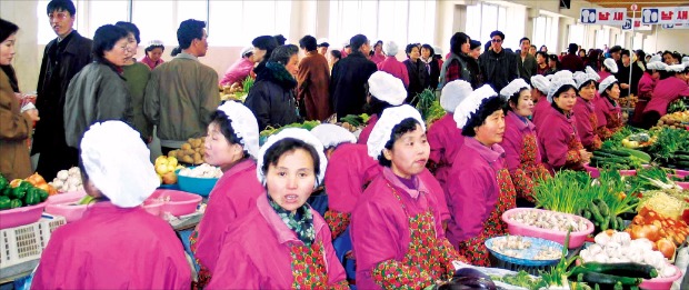 북한의 400여개의 장마당 중 최대 규모로 알려져 있는 평양 낙랑구역 통일거리 시장의 모습. 여성 판매원들이 매대에서 채소를 늘어놓고 판매하고 있다. 연합뉴스 