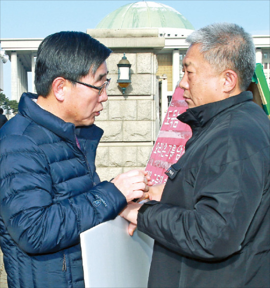 < 고용부 장관 - 한노총 위원장 국회 앞 대화 > 이기권 고용노동부 장관(왼쪽)이 지난달 30일부터 서울 여의도 국회 앞에서 1인 시위 중인 김동만 한국노총 위원장을 4일 만나 “청년·비정규직을 위해 노·사·정 논의 결과를 토대로 조속히 입법이 이뤄져야 한다”고 강조했다. 연합뉴스